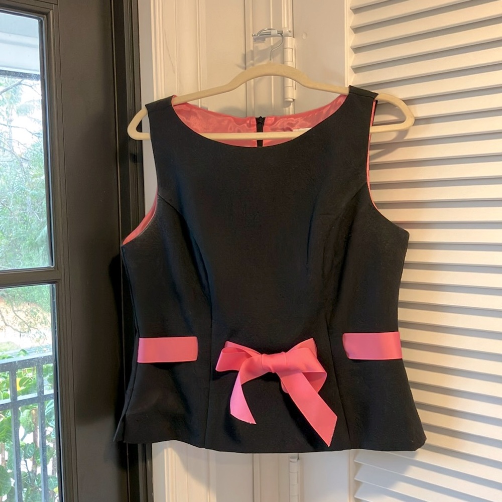 Black sleeveless pants suit with pink ribbon accents.